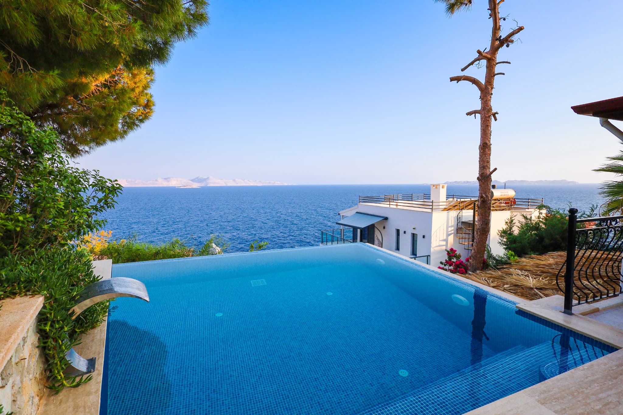 Private infinity pool overlooking the sea with natural landscape and Mediterranean views.