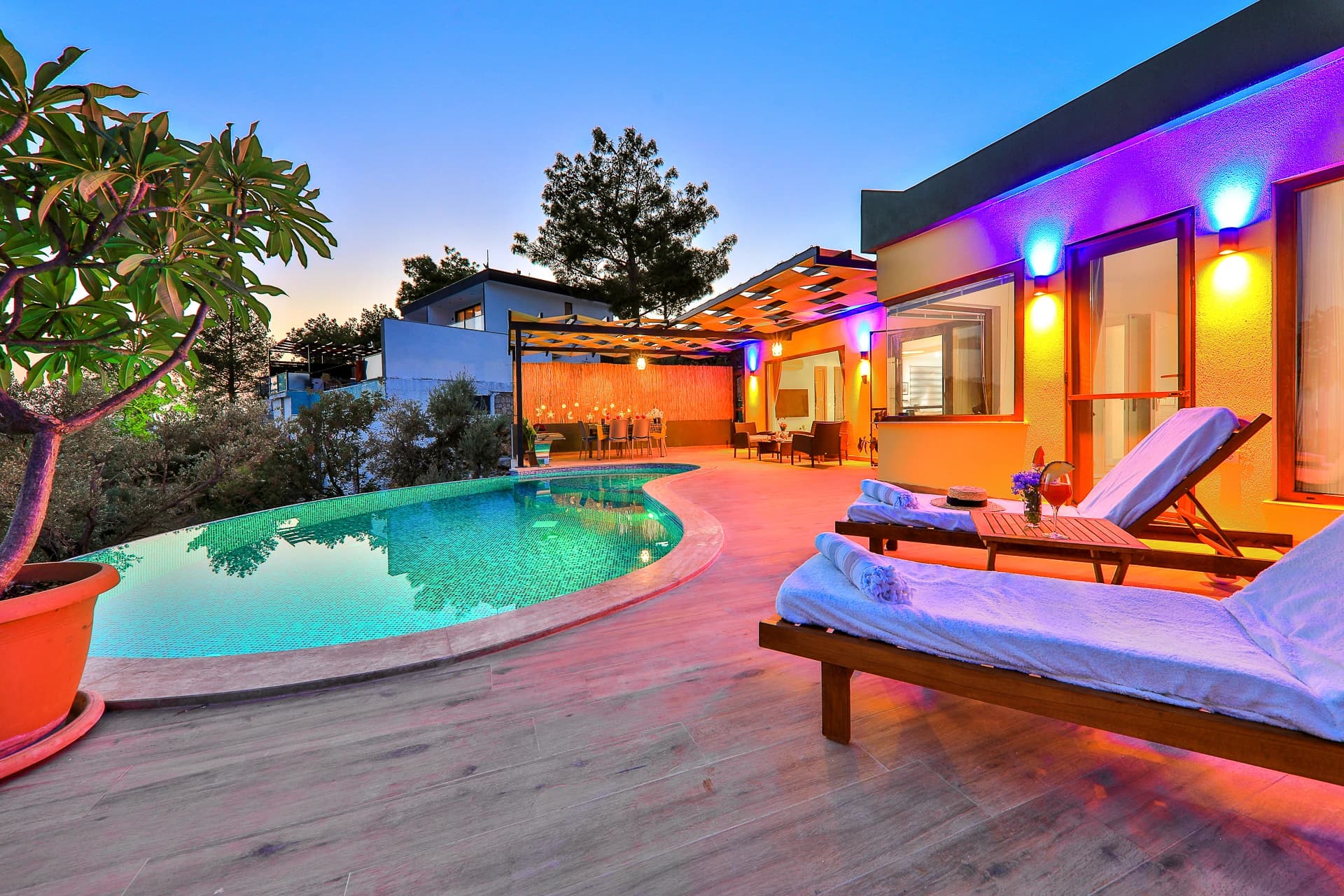 Resort-style pool area with lounge chairs and atmospheric outdoor lighting.