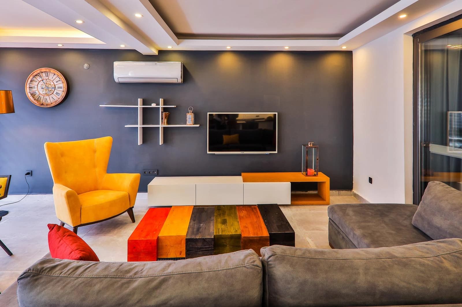 Contemporary living room with stylish furnishings, modern entertainment center, and accent lighting.
