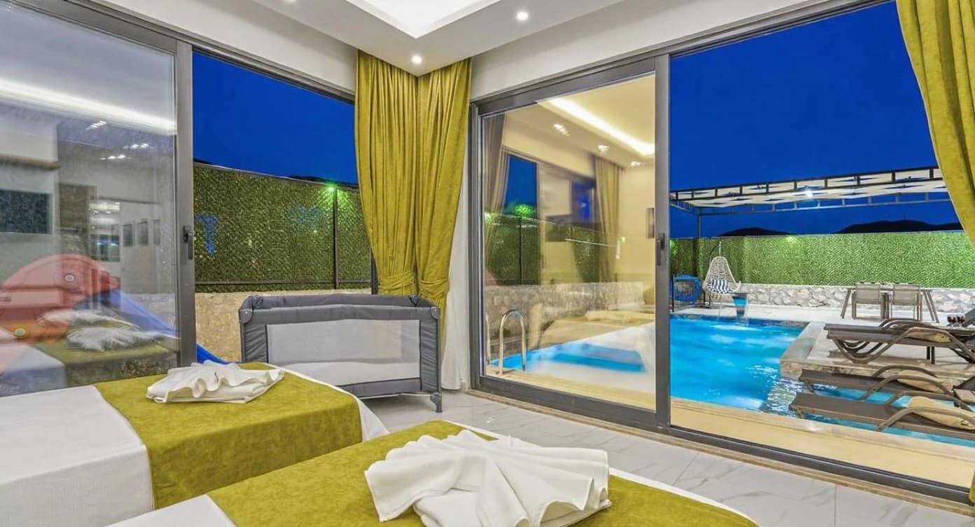 Bedroom with twin beds, pool-view sliding doors, and access to the terrace area.