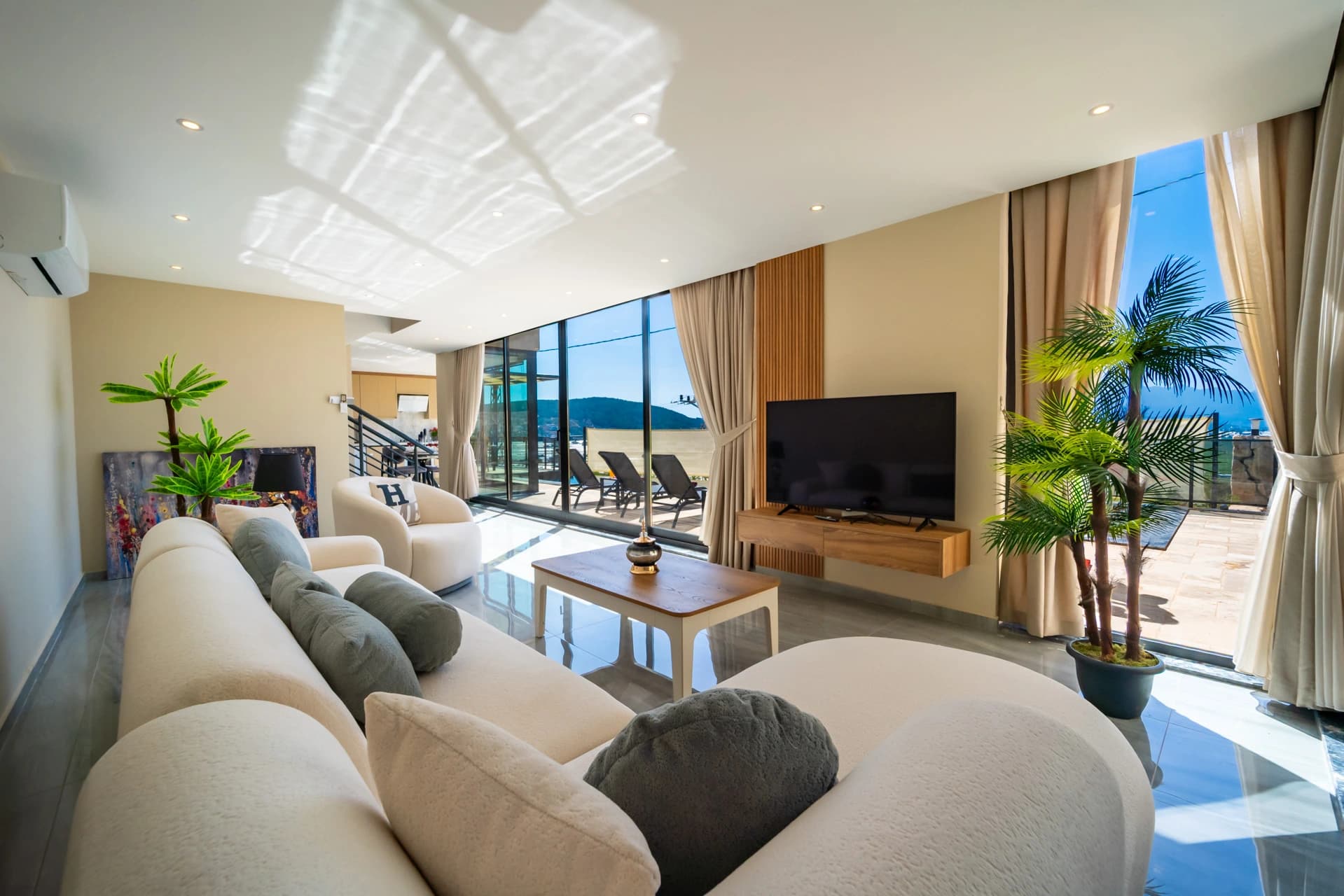 Bright open-plan living room with panoramic sea views and contemporary furnishings.