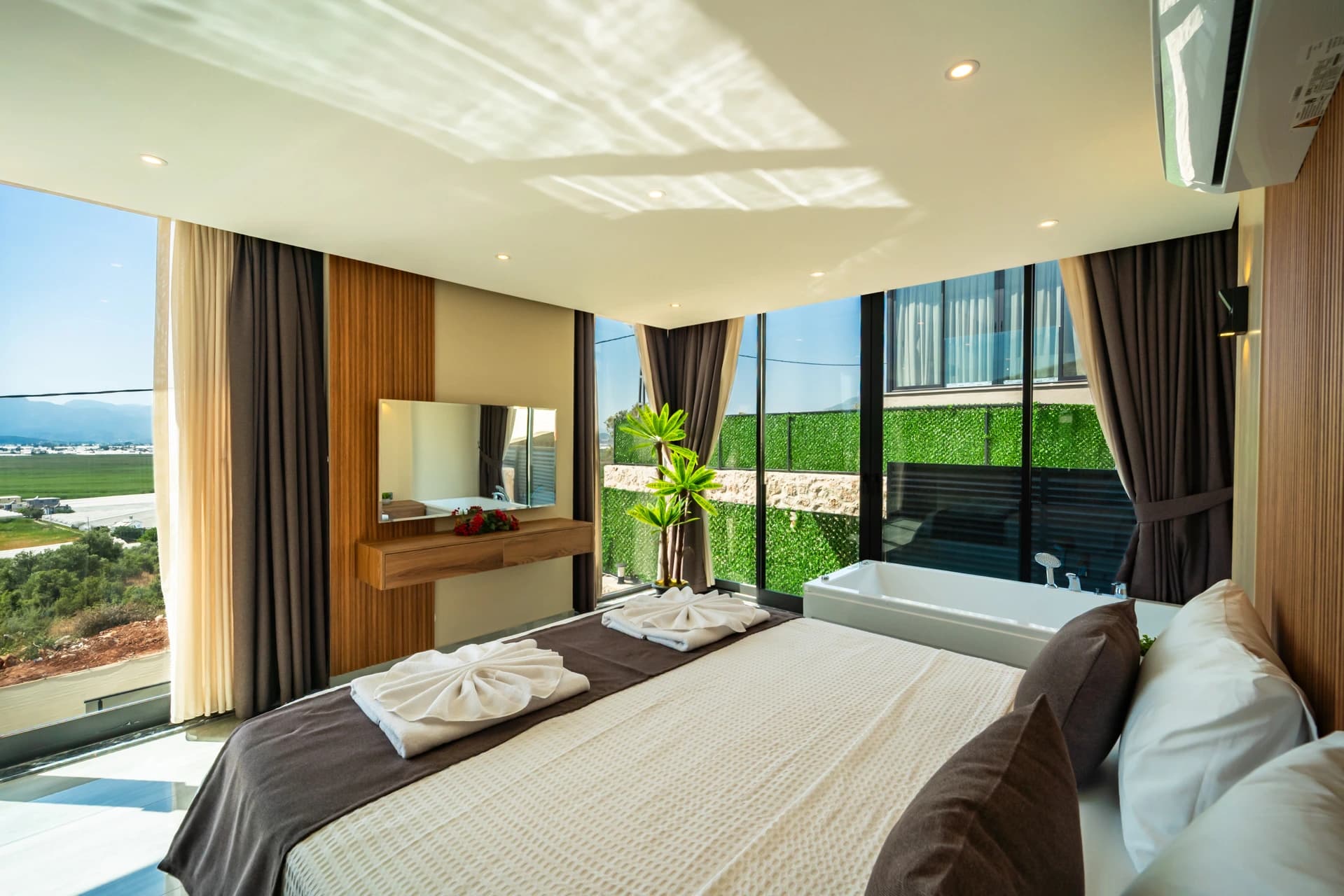 Spacious bedroom with twin beds, panoramic mountain views, and direct ensuite access.