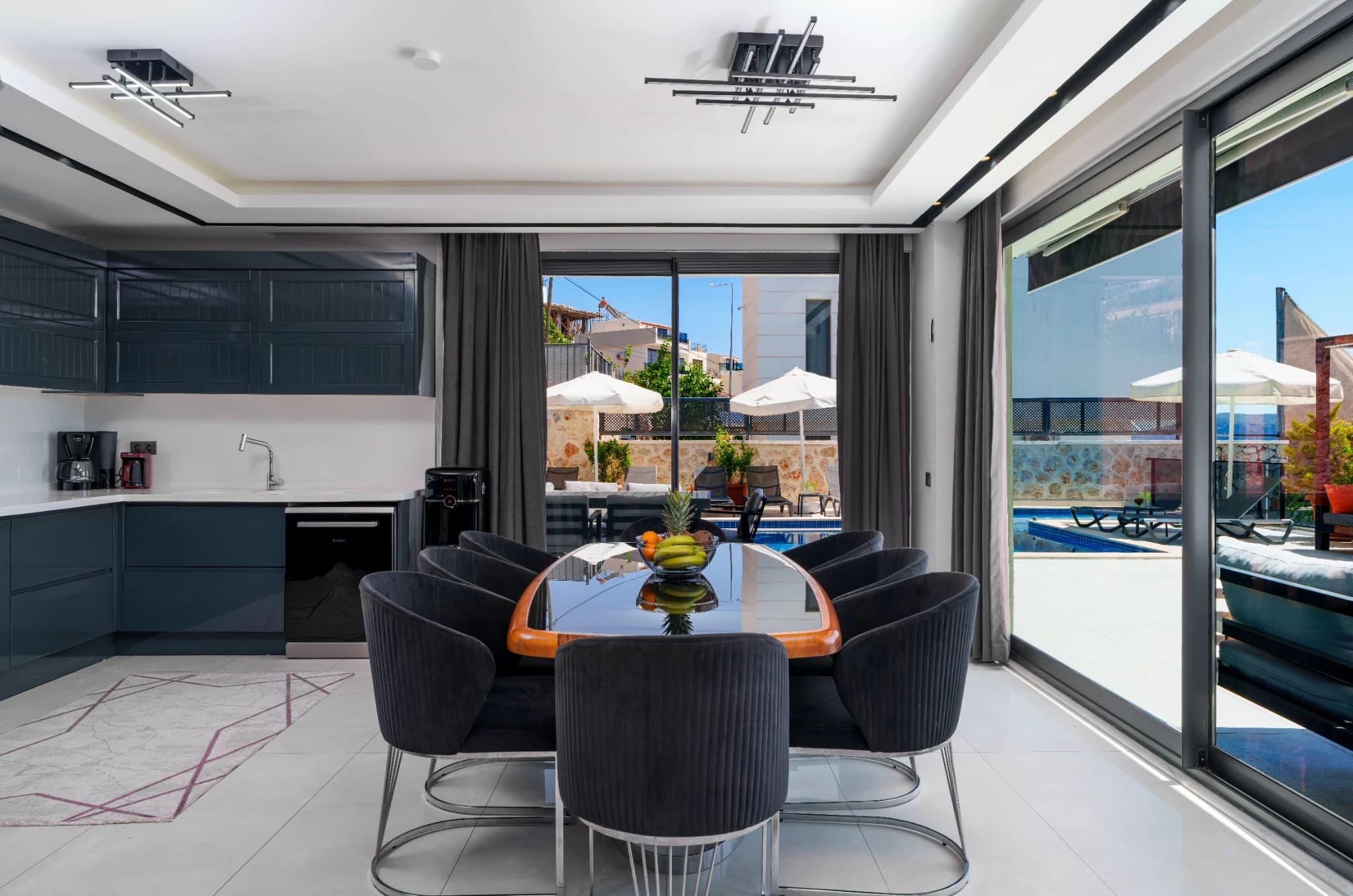 Open-plan dining and kitchen with panoramic sea and pool views.