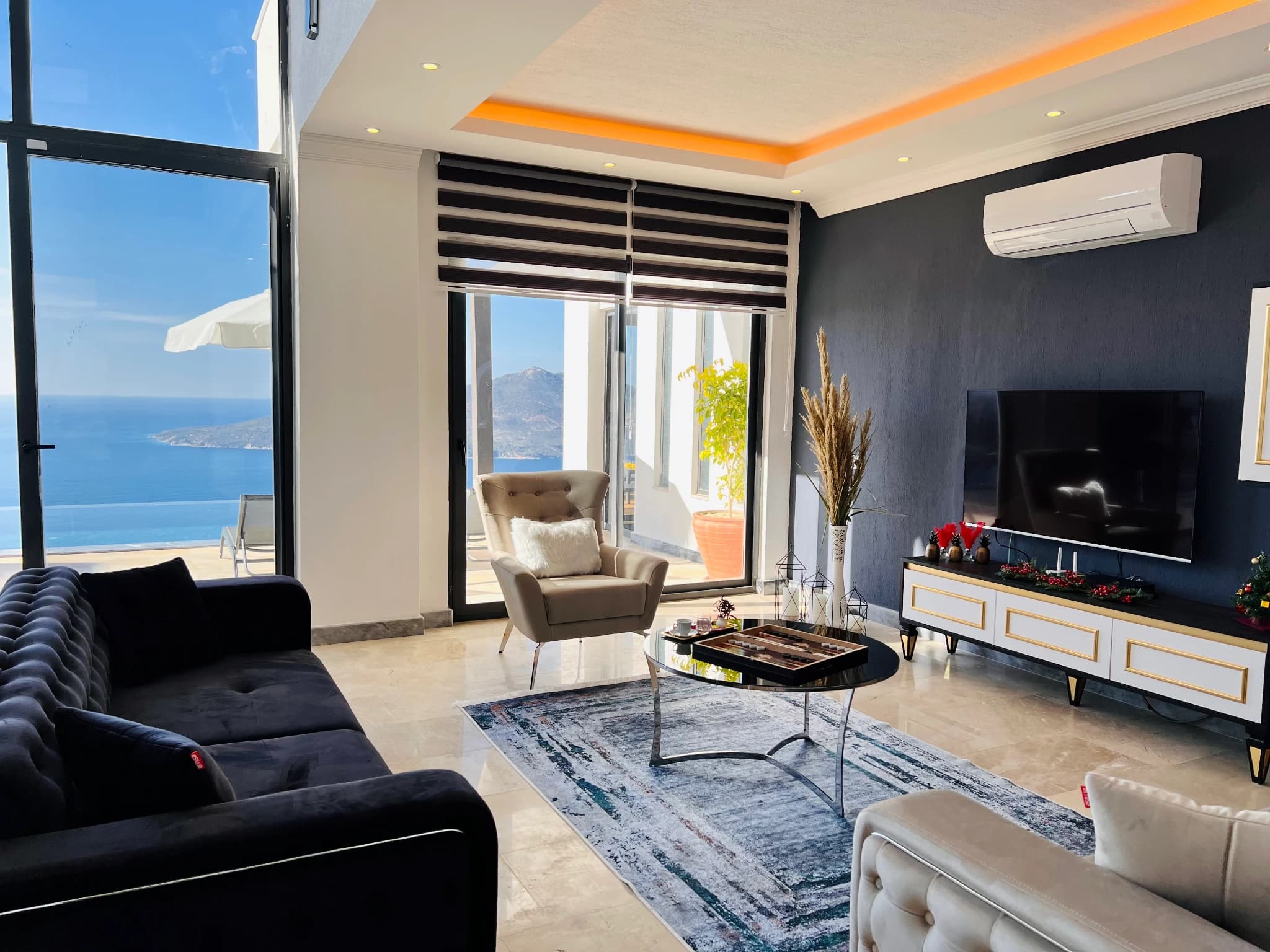 Contemporary living room with comfortable seating, smart TV, and stunning sea view.