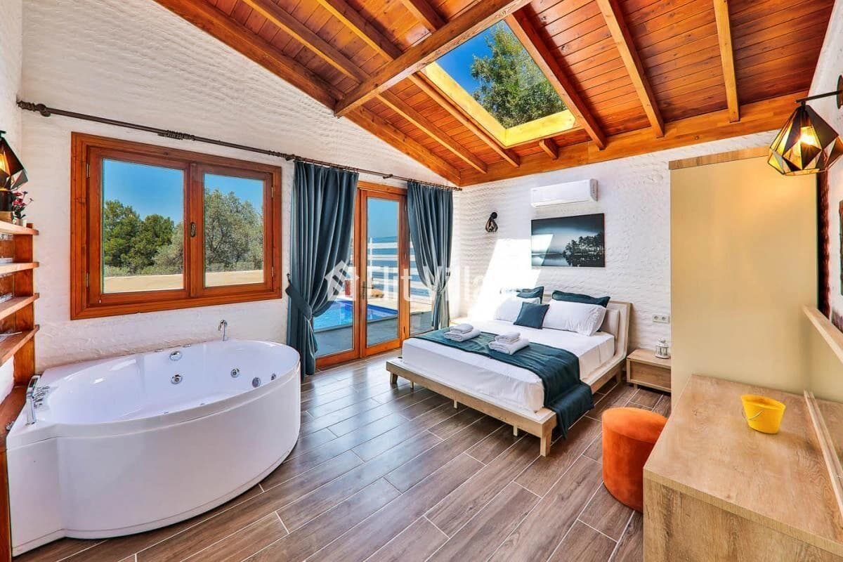 Luxurious master bedroom with king bed, in-room jacuzzi, and panoramic sea views.