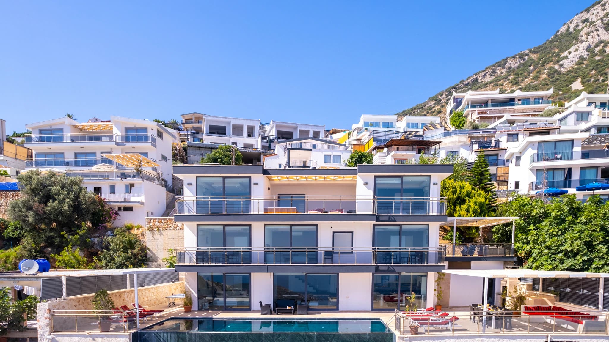 Modern hillside villa with private pool, sun loungers, and expansive sea views.