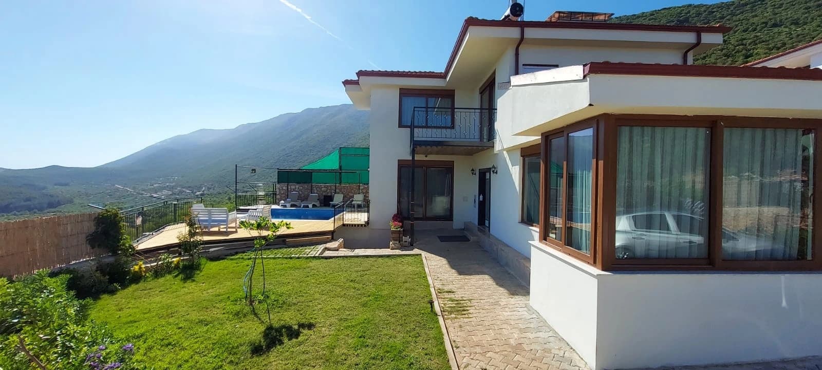Abgeschiedene 3-Zimmer-Villa mit privatem Pool und Bergblick in Kaş – Contemporary villa exterior with manicured lawn, pool area, and mountain scenery.
