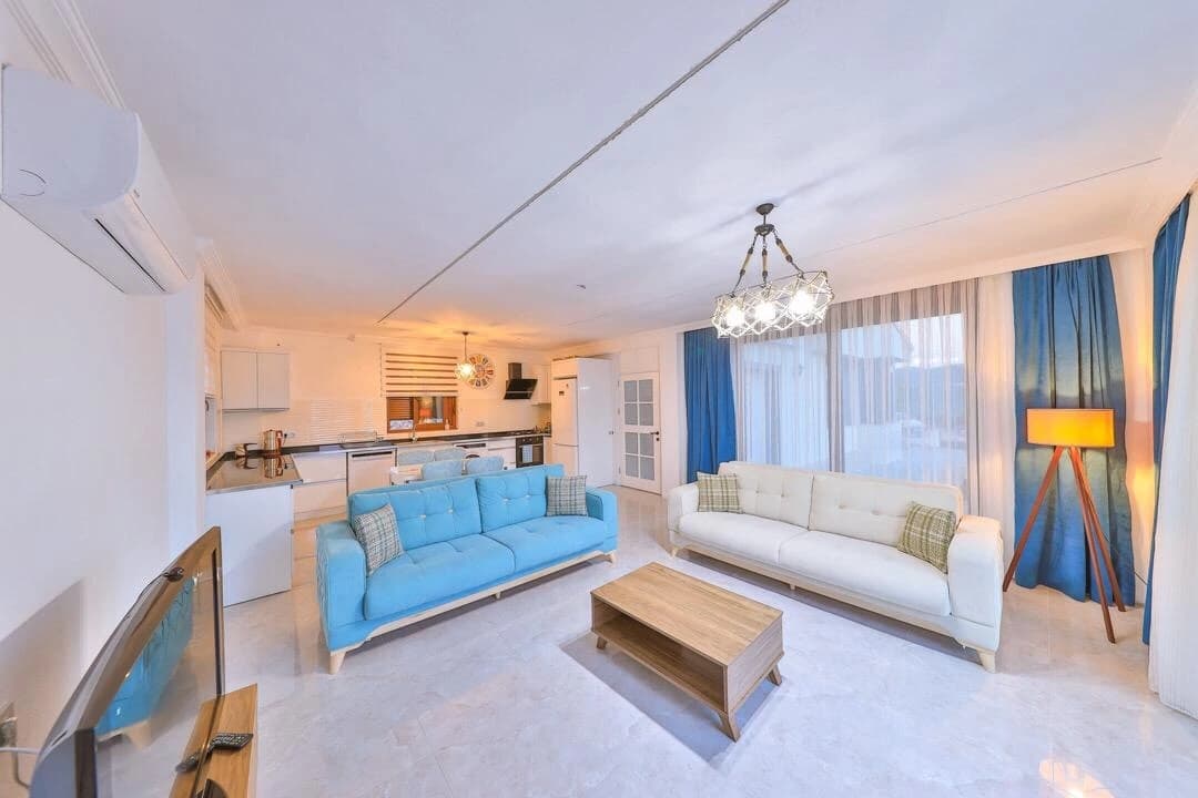 Abgeschiedene 3-Zimmer-Villa mit privatem Pool und Bergblick in Kaş – Spacious open-plan living area with modern seating and integrated kitchen.