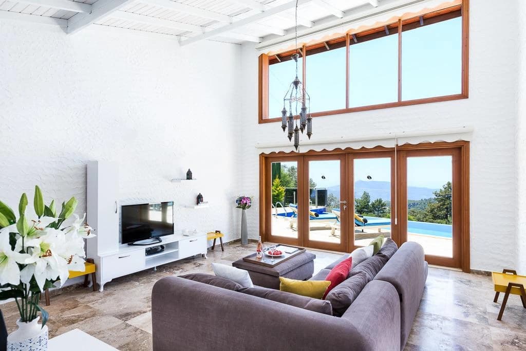 Spacious open-plan living room with pool and landscape views.