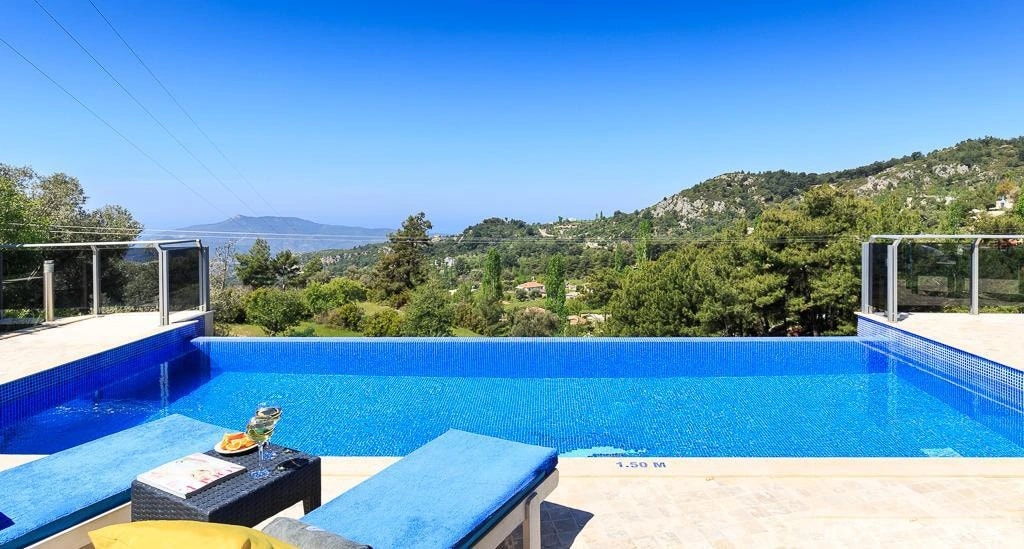 Infinity-edge pool with panoramic sea and mountain views.