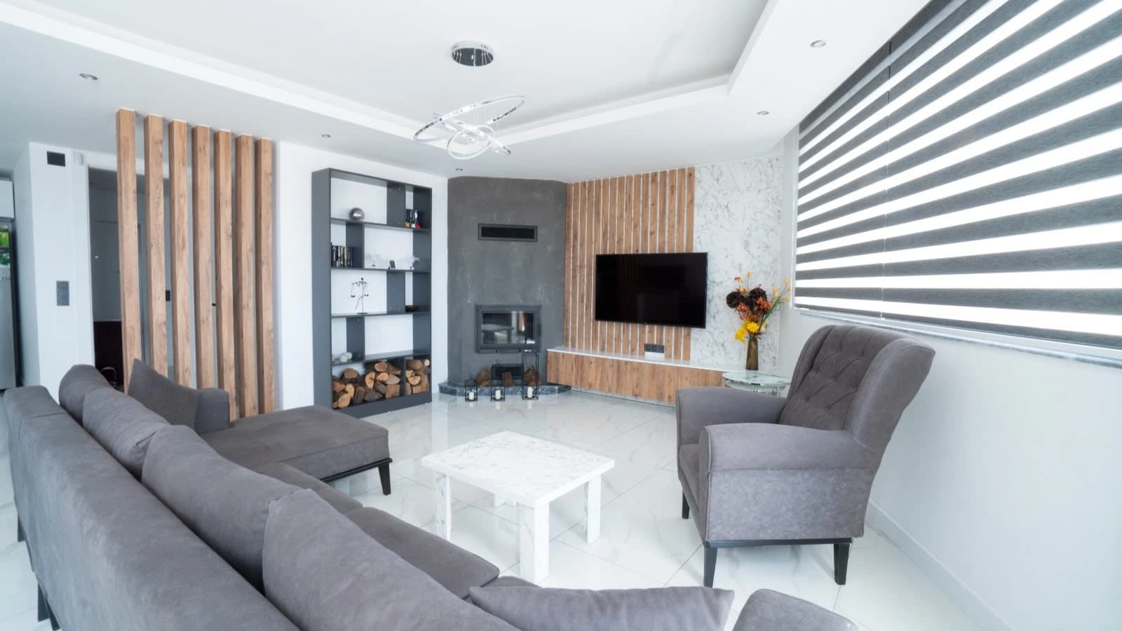 Contemporary living room with fireplace, seating area, and wall-mounted TV.