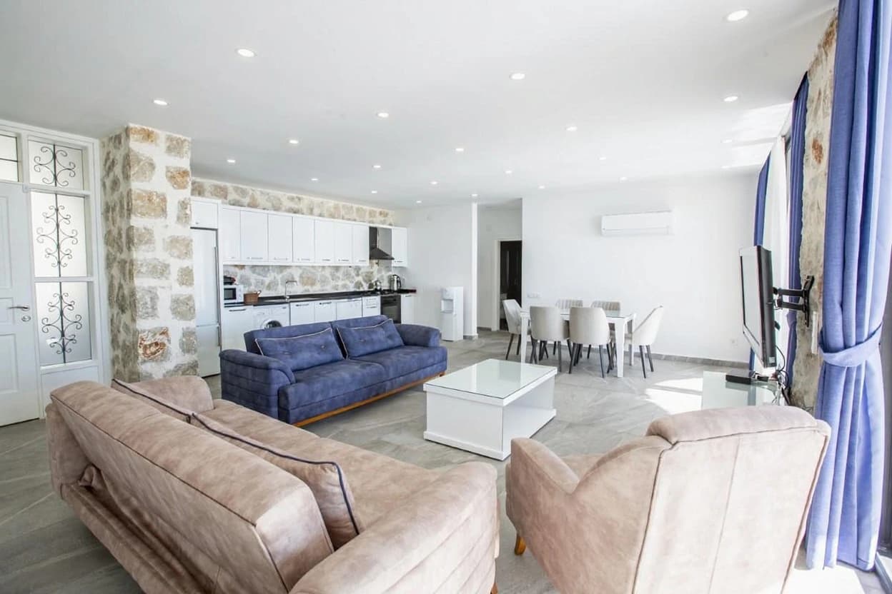 Large open-plan area combining lounge, kitchen and dining with architectural stone features.