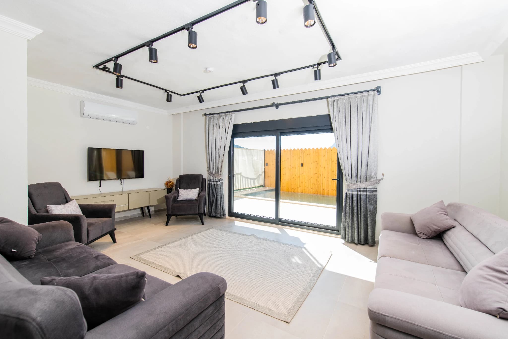 Spacious modern living room with multiple seating areas and direct access to outdoor terrace.