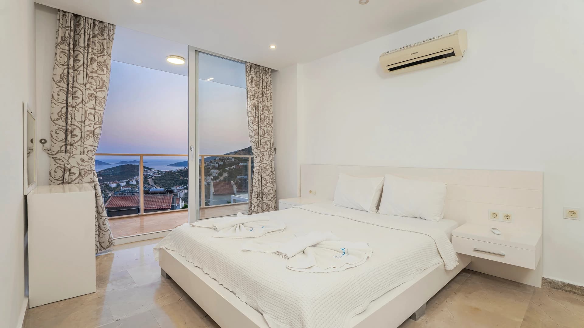 Master bedroom with king bed and stunning twilight sea views from private balcony.