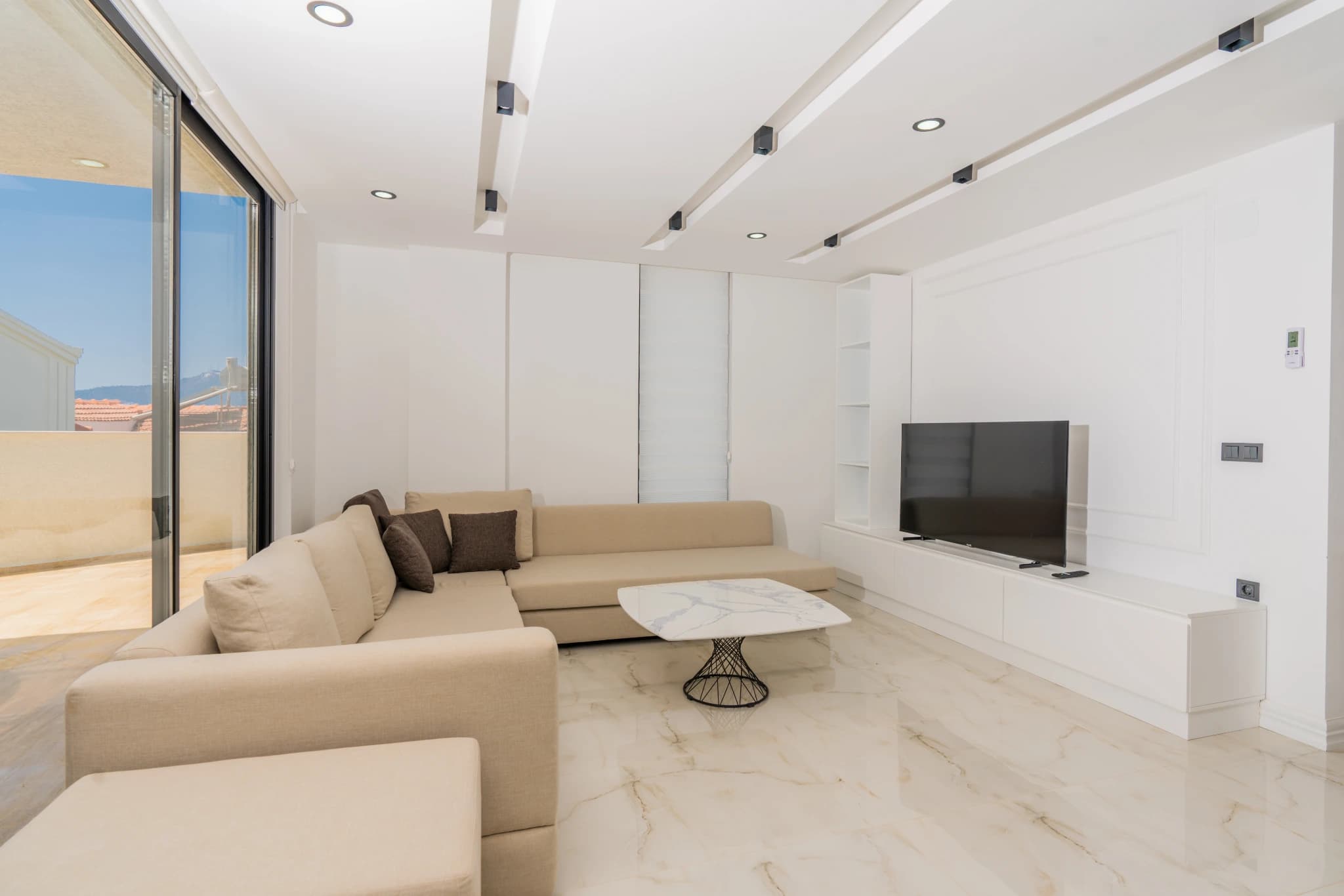 Contemporary living area with cream sectional and seamless indoor-outdoor flow.