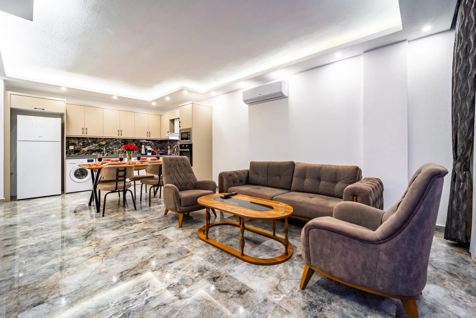 Open-plan living and dining area with kitchen and contemporary furnishings.