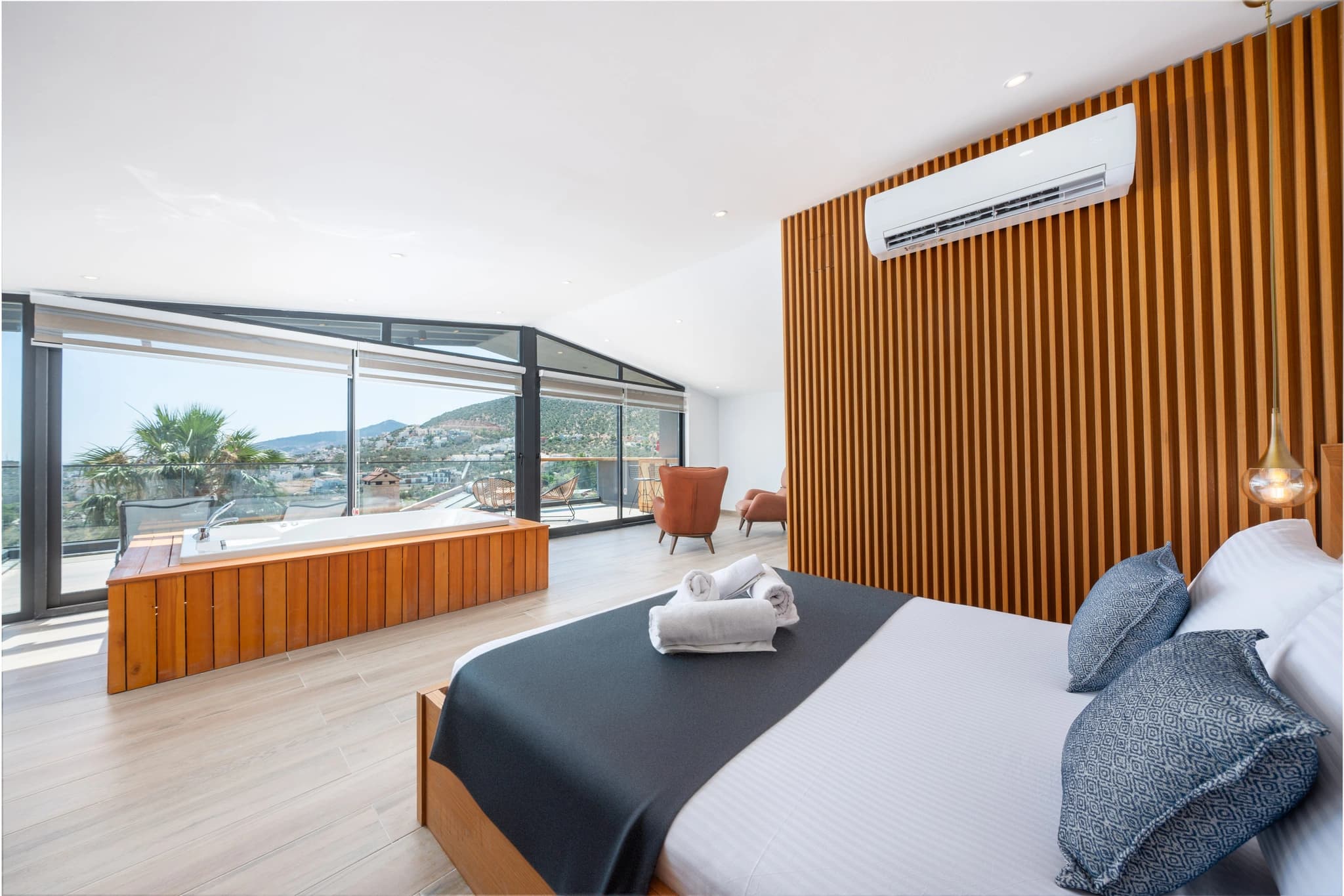 Premium master bedroom with king bed, spa jacuzzi, and panoramic mountain and sea views.