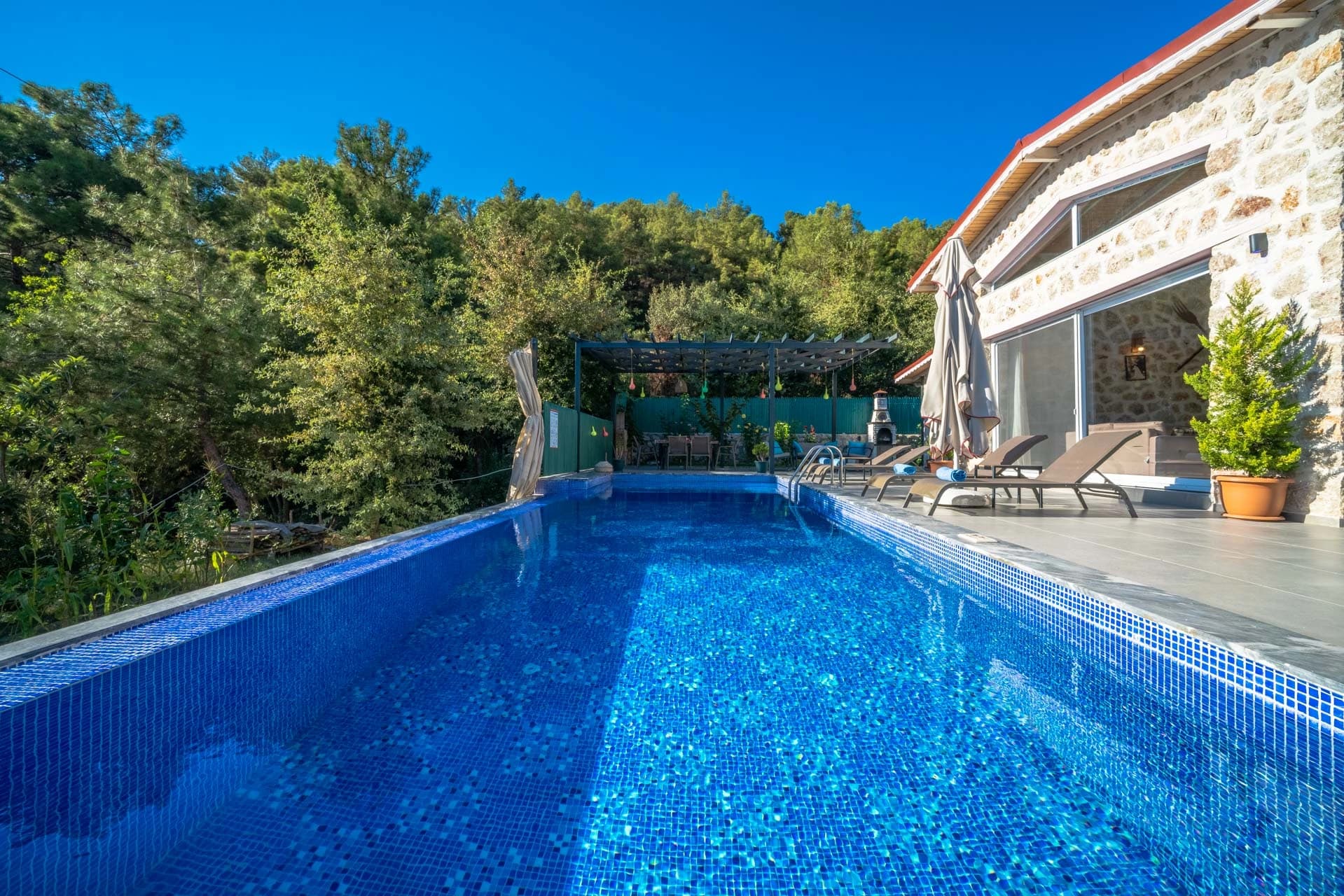 Stunning private lap pool with sun loungers overlooking lush gardens.