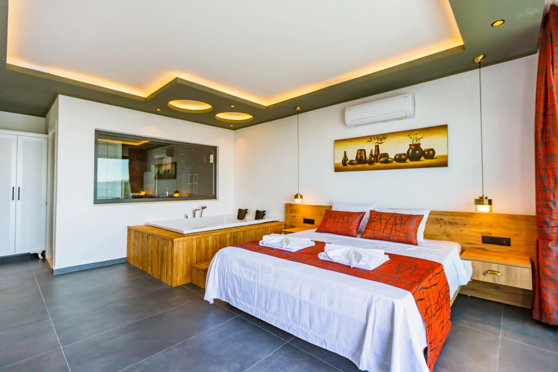 Luxurious master bedroom with ensuite jacuzzi bathtub and modern wood-finished furnishings.