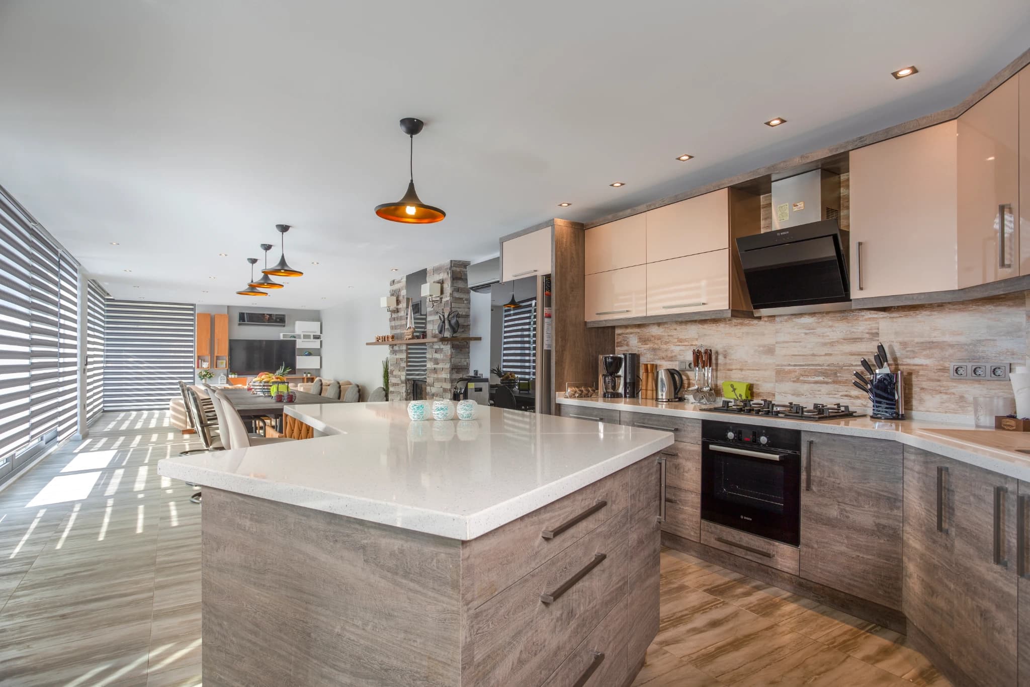 Well-lit kitchen with white island countertop and integrated appliances.
