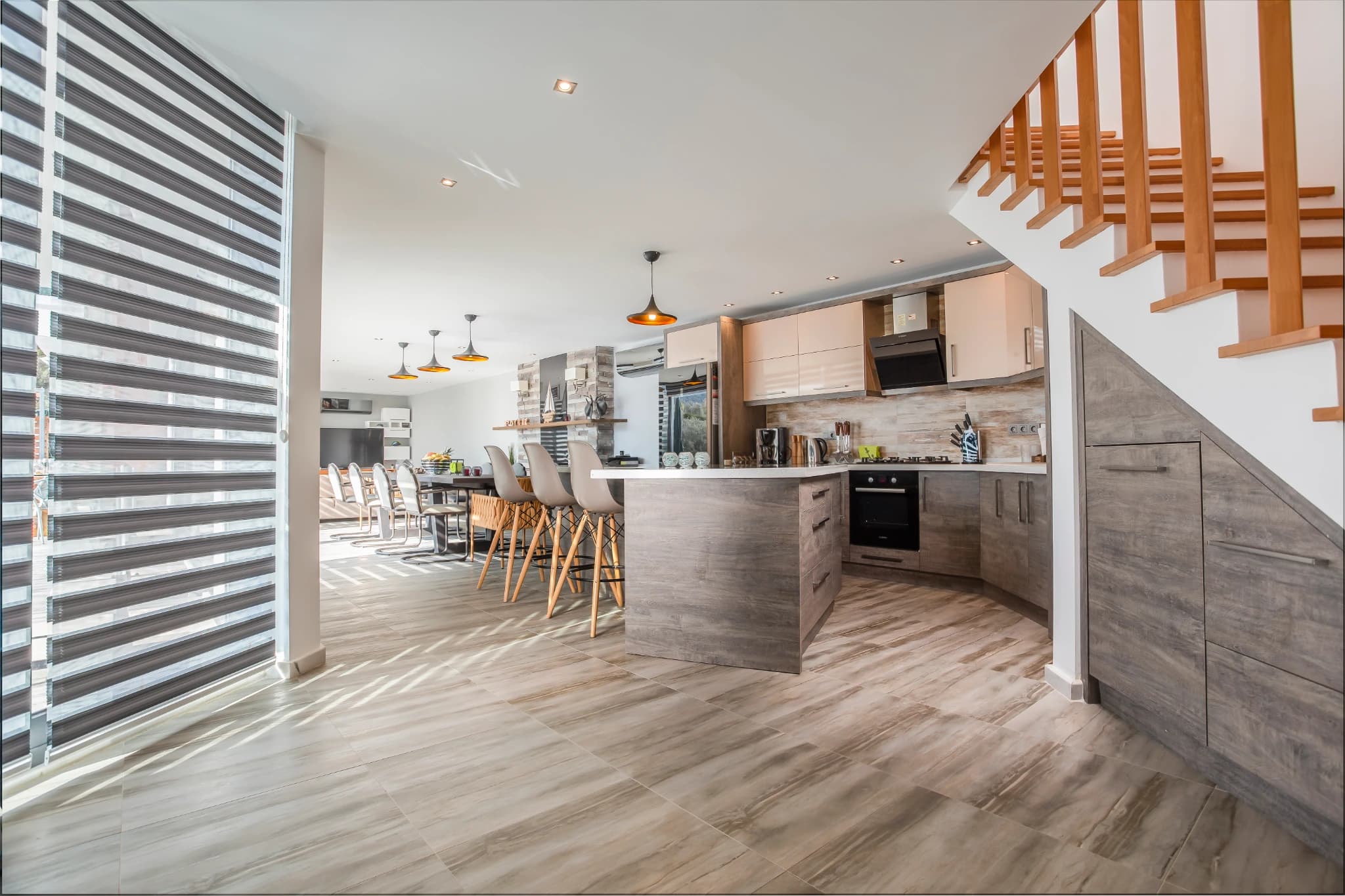 Modern kitchen with central island and bar seating in open-plan layout.