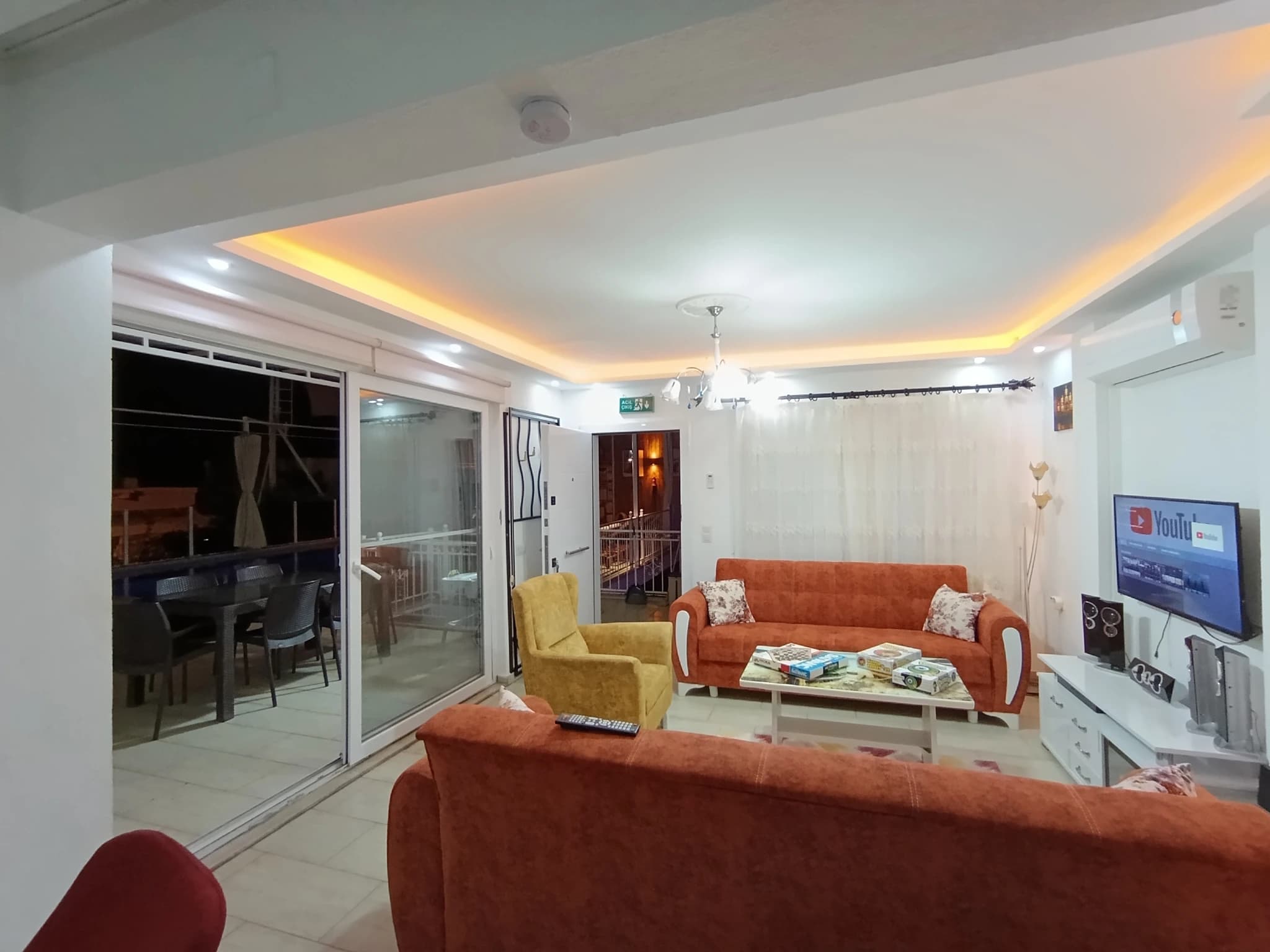 Geschützte Villa mit Naturblick, Privatpool und Garten in Kalkan – Bright living room with multiple seating areas, large glass doors opening to a balcony, and mounted TV.