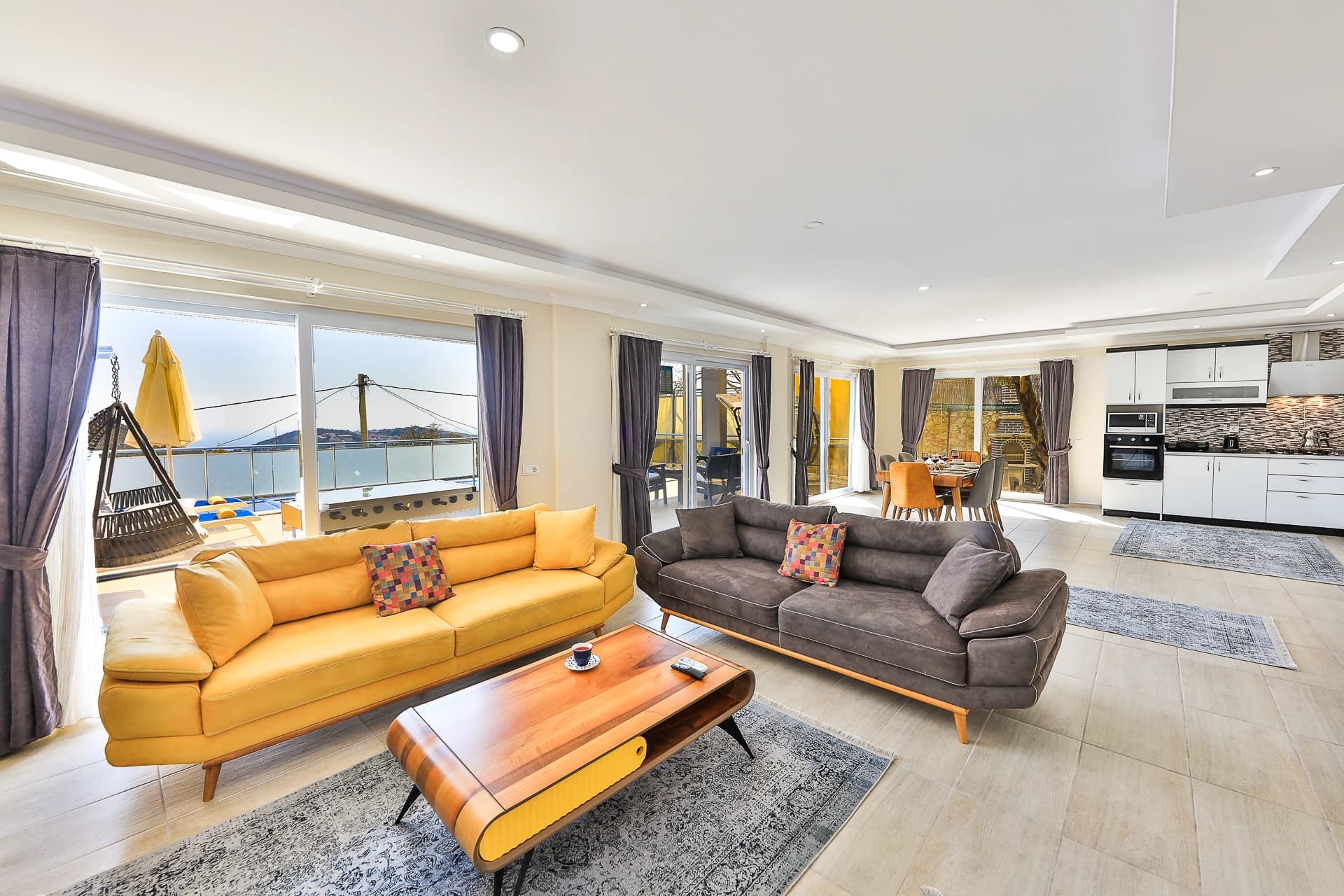 Spacious open-plan living room with dual sofas and expansive sea views.