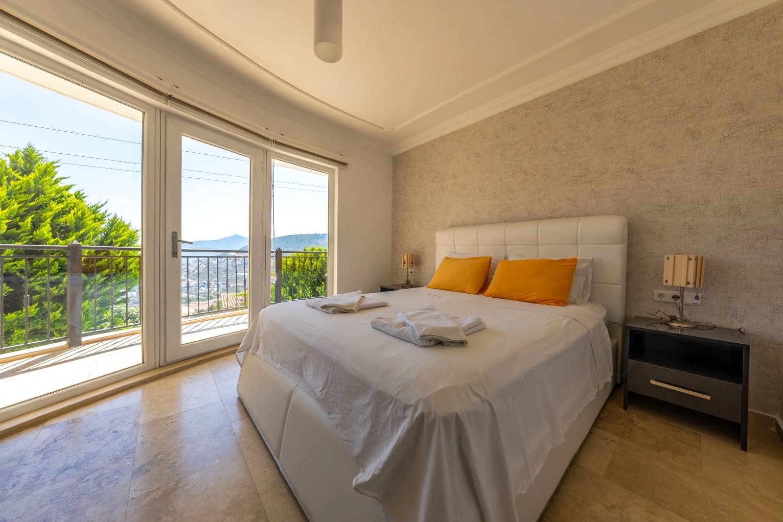 Spacious bedroom with king bed, sea and mountain views from private balcony.