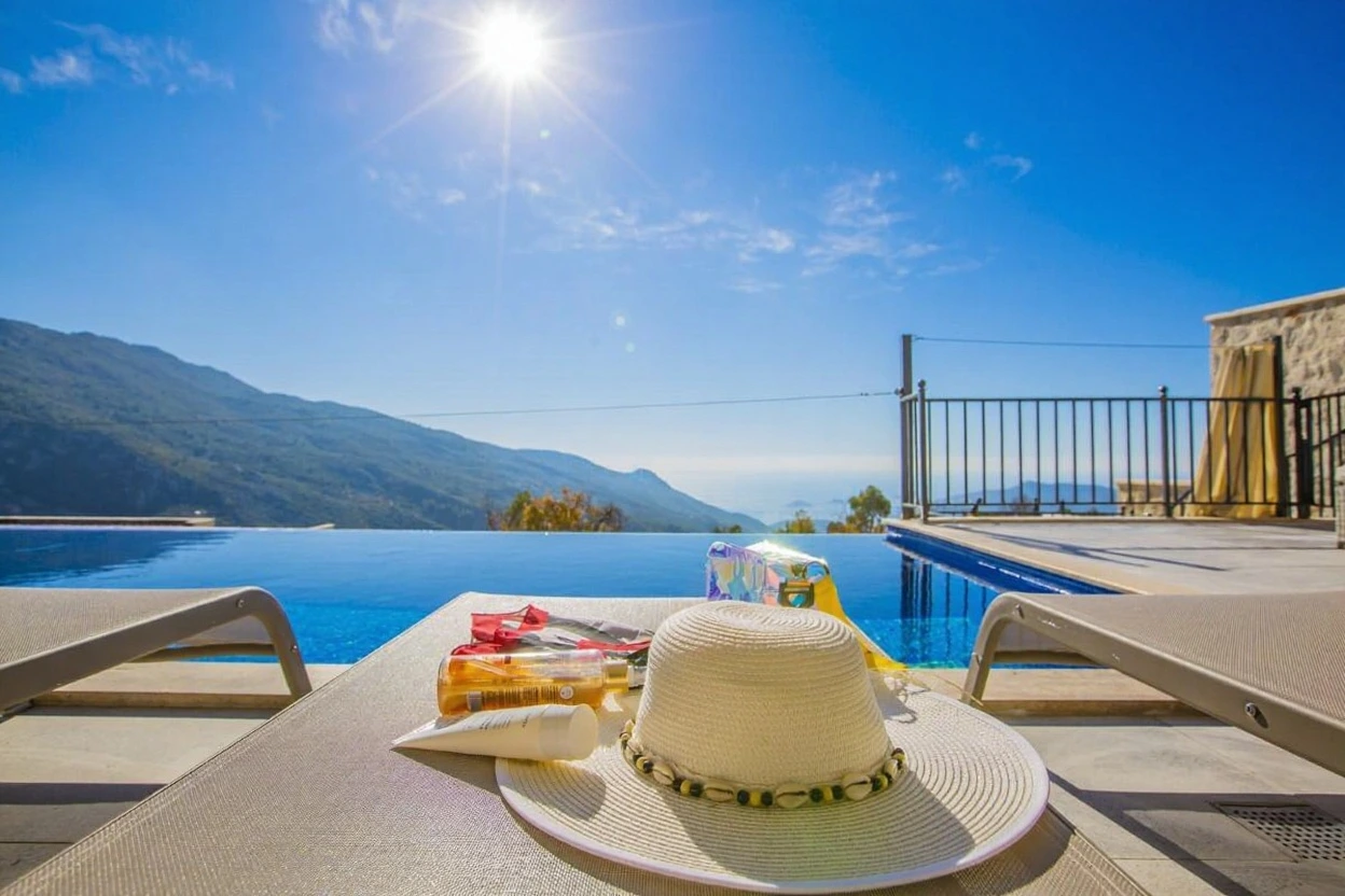 Inviting pool area with loungers and panoramic views of verdant mountains.