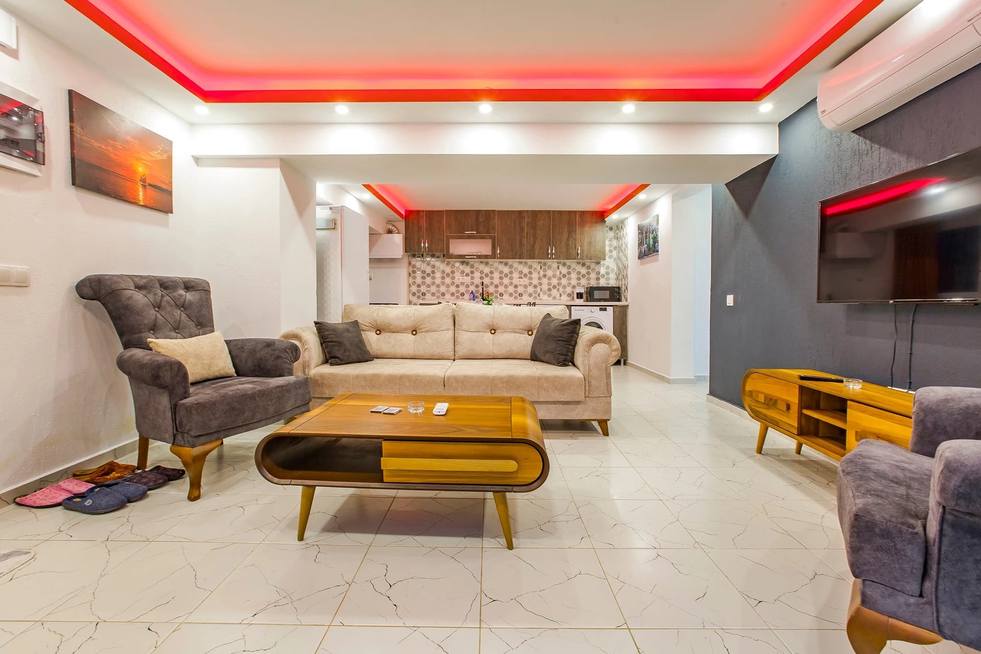 Abgeschiedene Waldvilla mit privatem Pool und Jacuzzi-Suite bei Kalkan – Open-plan living room with sofa seating, integrated kitchenette, and striking red accent ceiling.