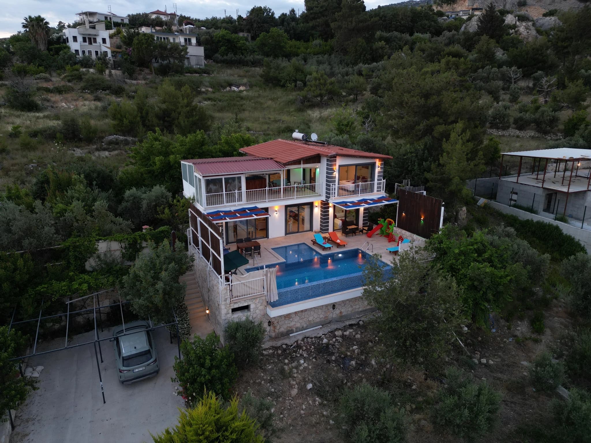 Abgeschiedene Villa mit Natur- und Bergblick, Innen- und Außenpool bei Kalkan – Angled exterior view showing the villa's modern architecture and integrated pool.
