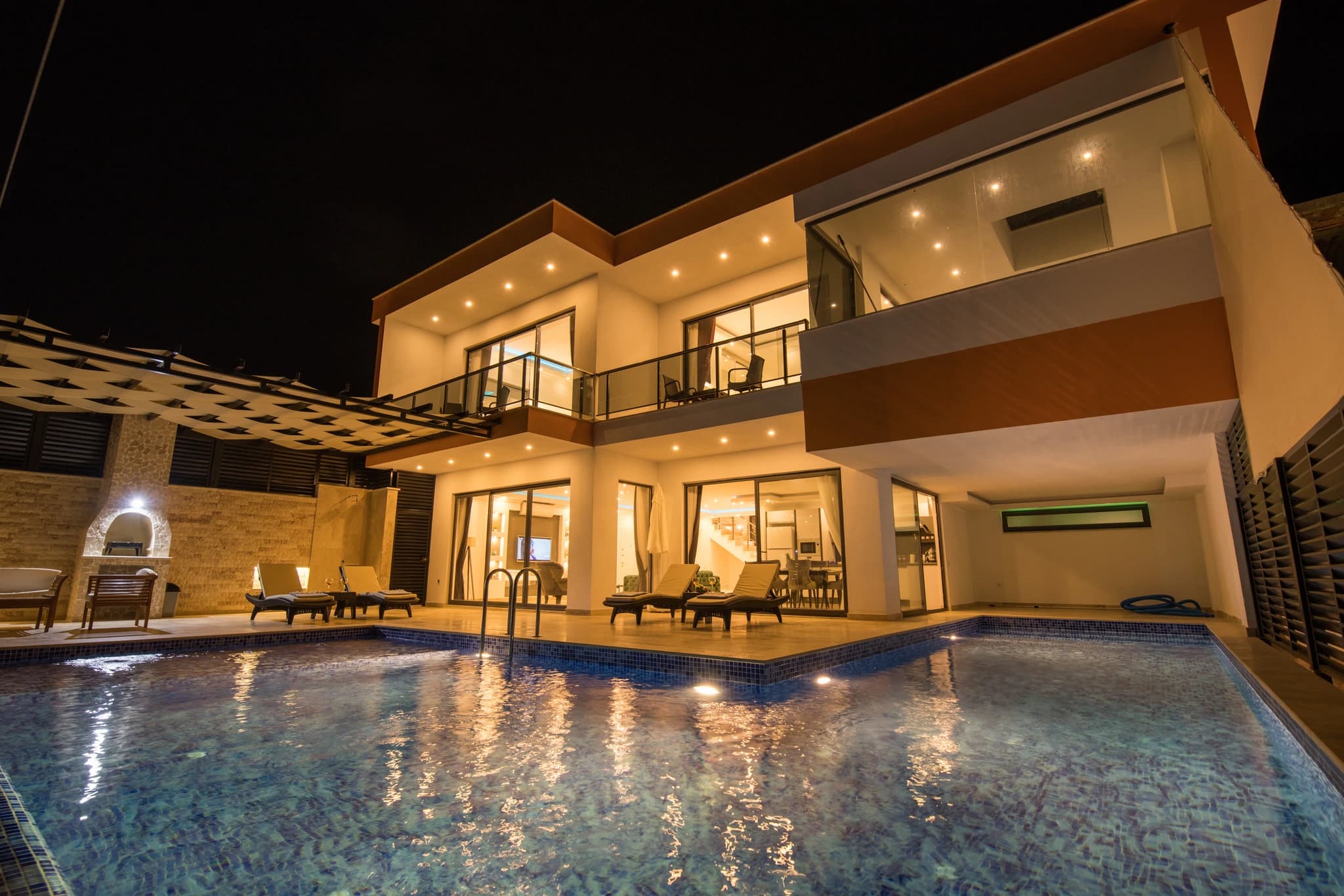 Abgeschiedene Honeymoon-Villa mit Meerblick, Innen- und Außenpool in Kalkan – Beautifully illuminated villa facade at night with glowing pool and terrace.