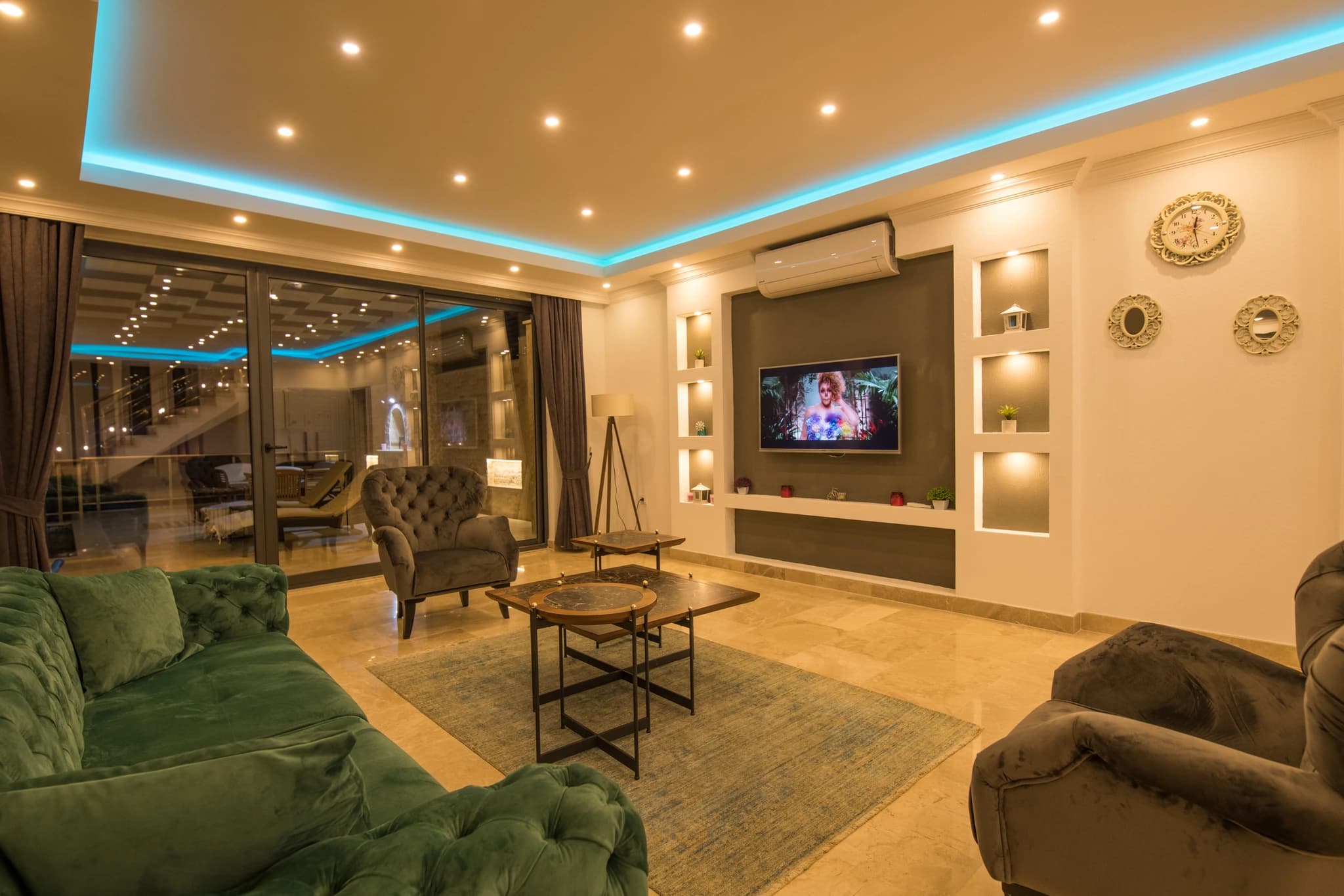 Abgeschiedene Honeymoon-Villa mit Meerblick, Innen- und Außenpool in Kalkan – Luxurious modern living room with plush seating, entertainment system, and ambient ceiling lighting.