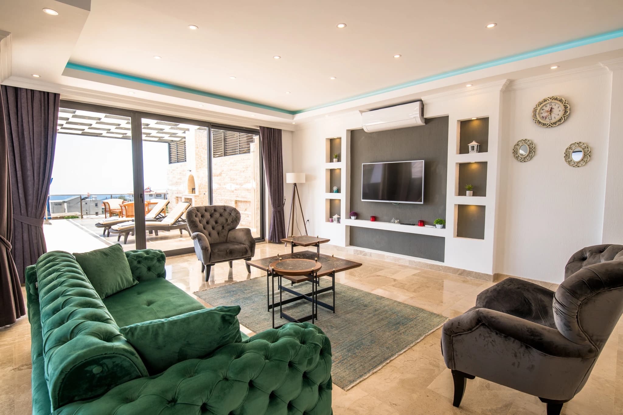 Abgeschiedene Honeymoon-Villa mit Meerblick, Innen- und Außenpool in Kalkan – Contemporary living room with velvet seating, flat-screen TV, and direct terrace access.