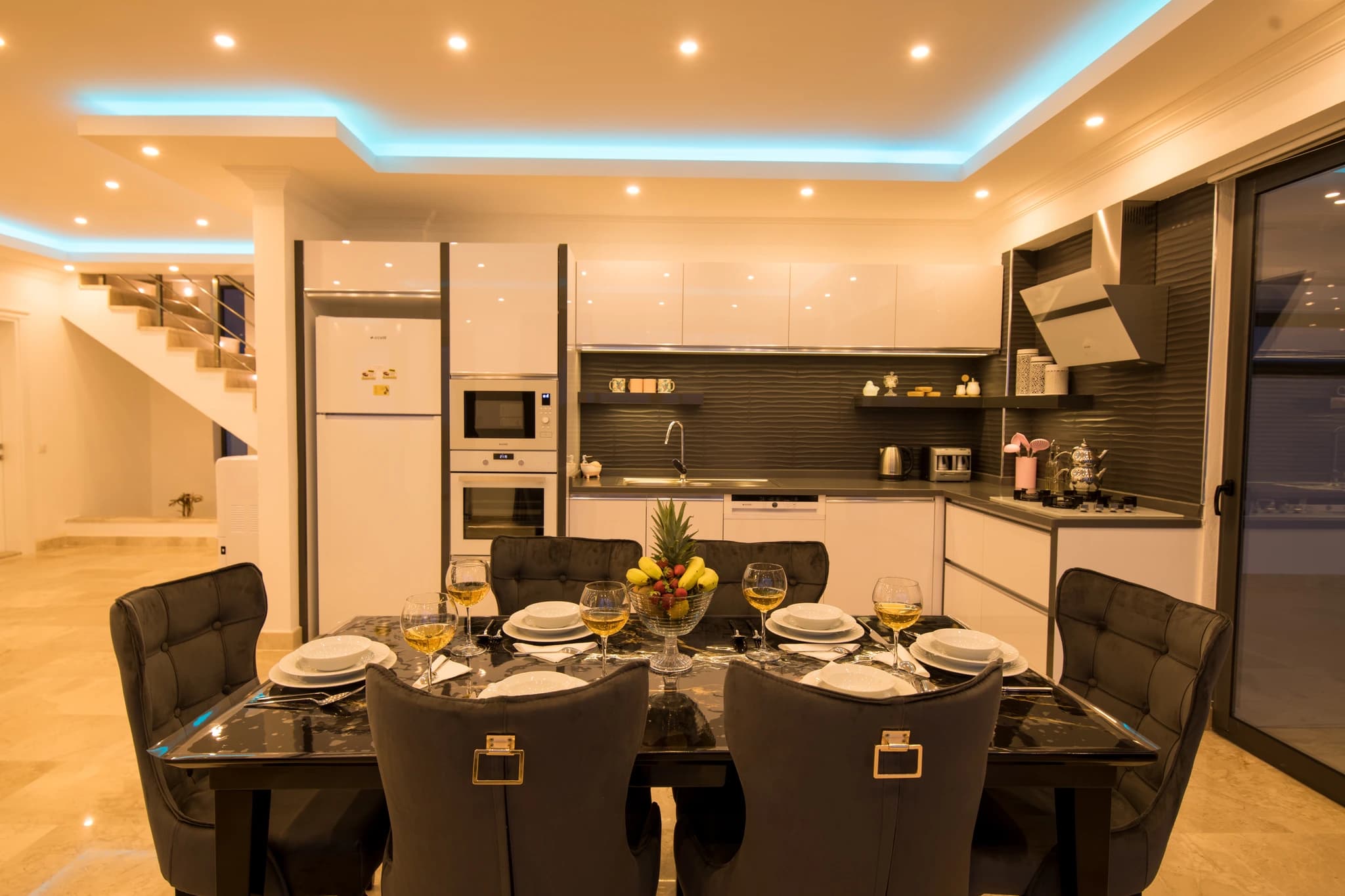 Abgeschiedene Honeymoon-Villa mit Meerblick, Innen- und Außenpool in Kalkan – Open-plan kitchen and dining area with black marble table and modern appliances.