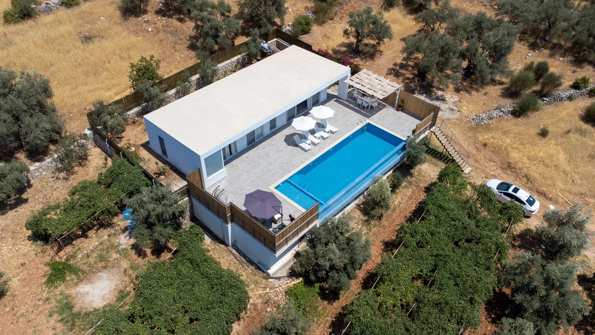 Abgeschiedene 2-Zimmer-Villa mit Infinity-Pool und Bergblick bei Kalkan – Elevated drone perspective showcasing the complete villa layout with pool complex and natural surroundings.