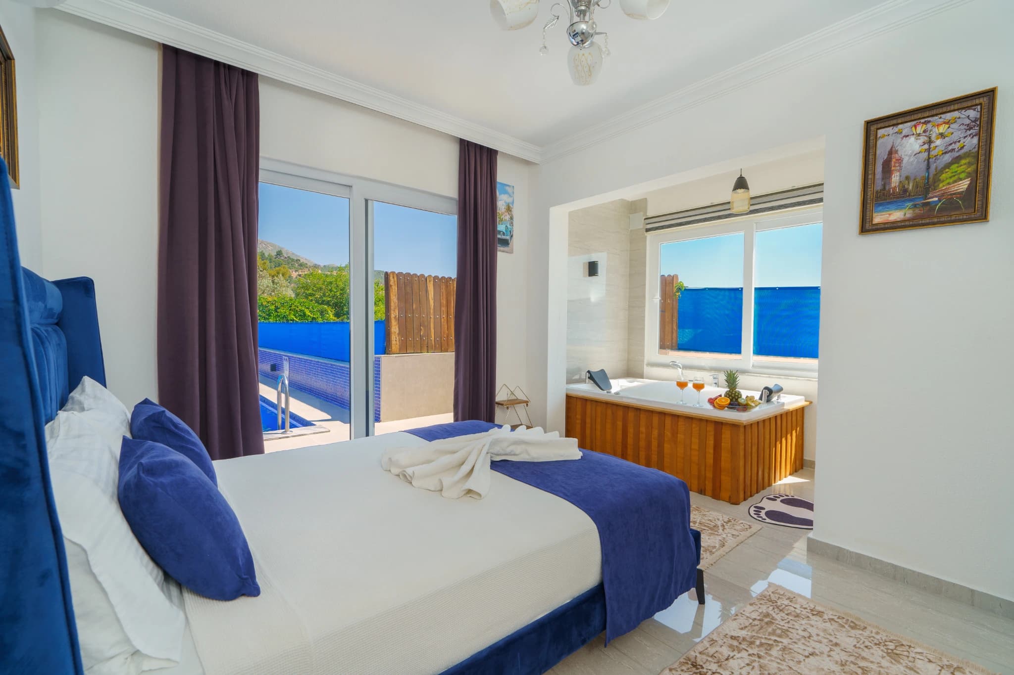 Master bedroom with king bed, ensuite bathtub, and panoramic sea views from the terrace.