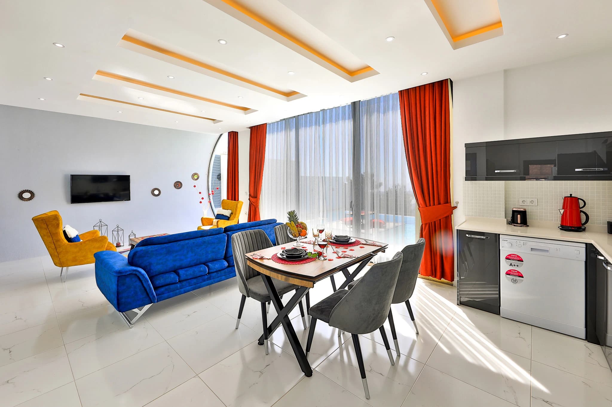 Open-plan living and dining area with blue sofa and integrated kitchen.