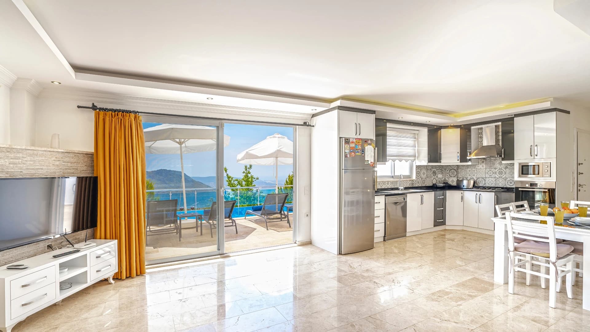 Secluded 2-Bedroom Villa with Heated Pool and Mountain & Sea Views in Kalkan – Spacious open-plan living and kitchen area with expansive sea views and access to terrace.
