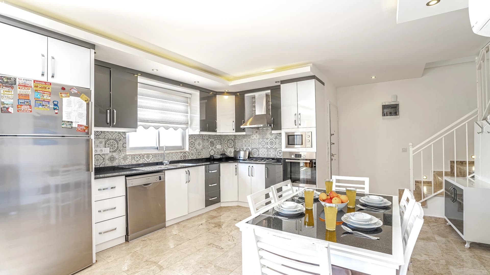 Secluded 2-Bedroom Villa with Heated Pool and Mountain & Sea Views in Kalkan – Spacious modern kitchen with island and integrated dining area, featuring quality appliances and stylish tile work.