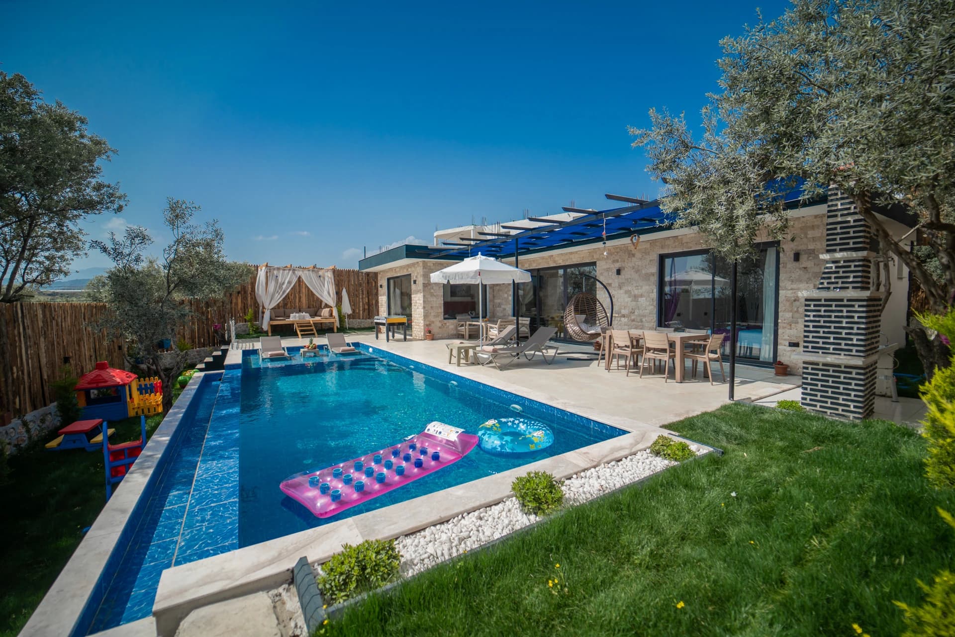 Stunning resort-style pool with lounging area, pergola, and manicured gardens.